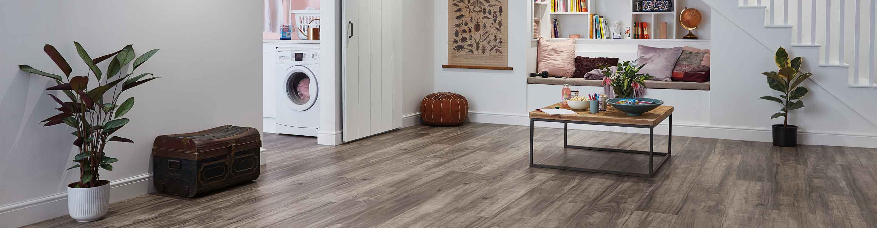 wood look vinyl flooring in living room with reading nook, coffee table, and pocket doors to laundry room